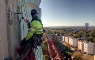 Pracownik firmy czyszczącej elewacje na wysokościach
