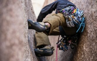 mężczyzna w uprzęży wspinaczkowej się wspina